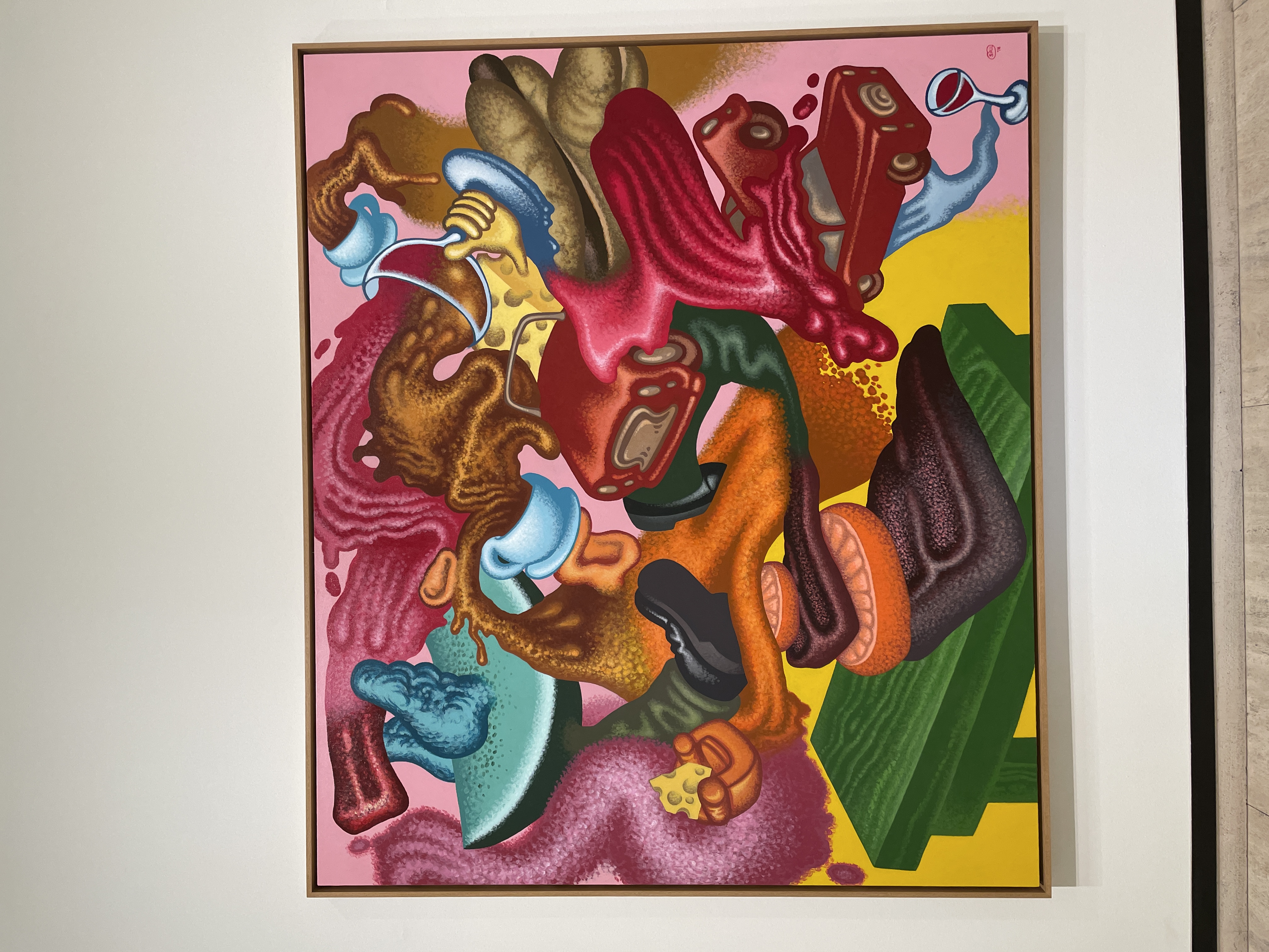 An abstract painting. Swirling pink tornado with a glass, cars, coffee, leg, and cheese around it.